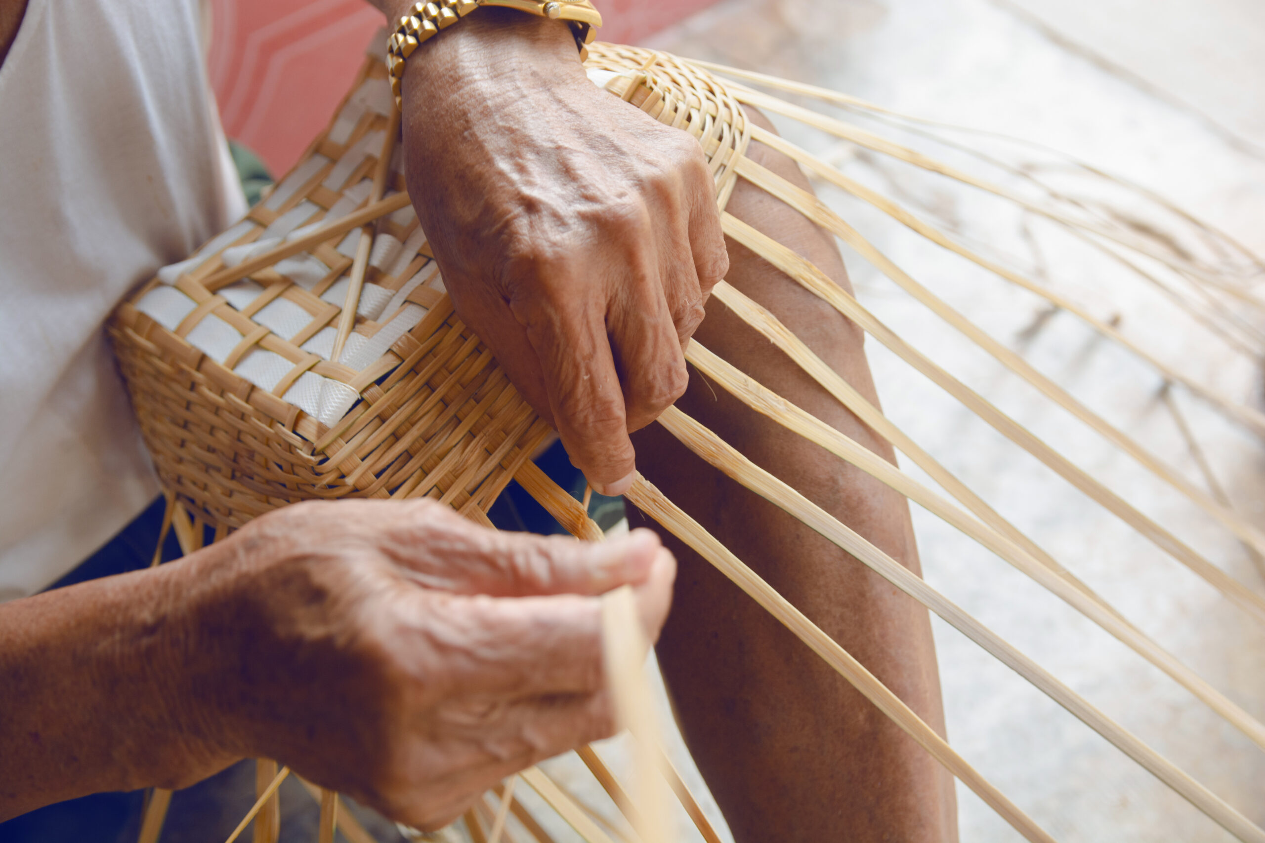 Senior man hands manually weaving bamboo.