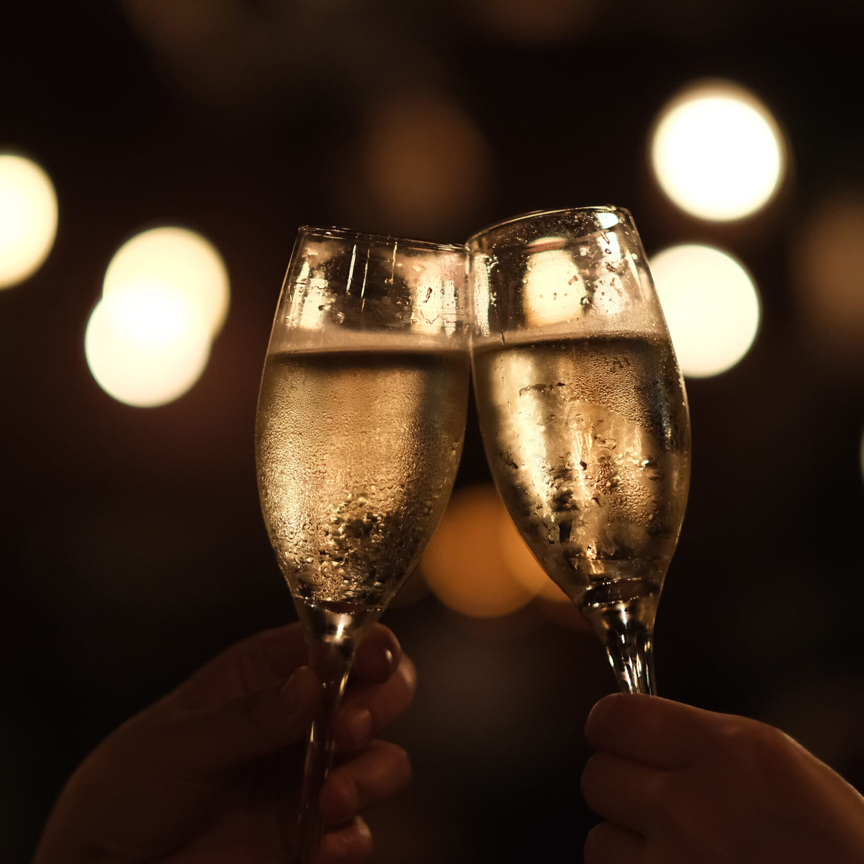 close up two hands holding drinking glass, cheers in darkness. G